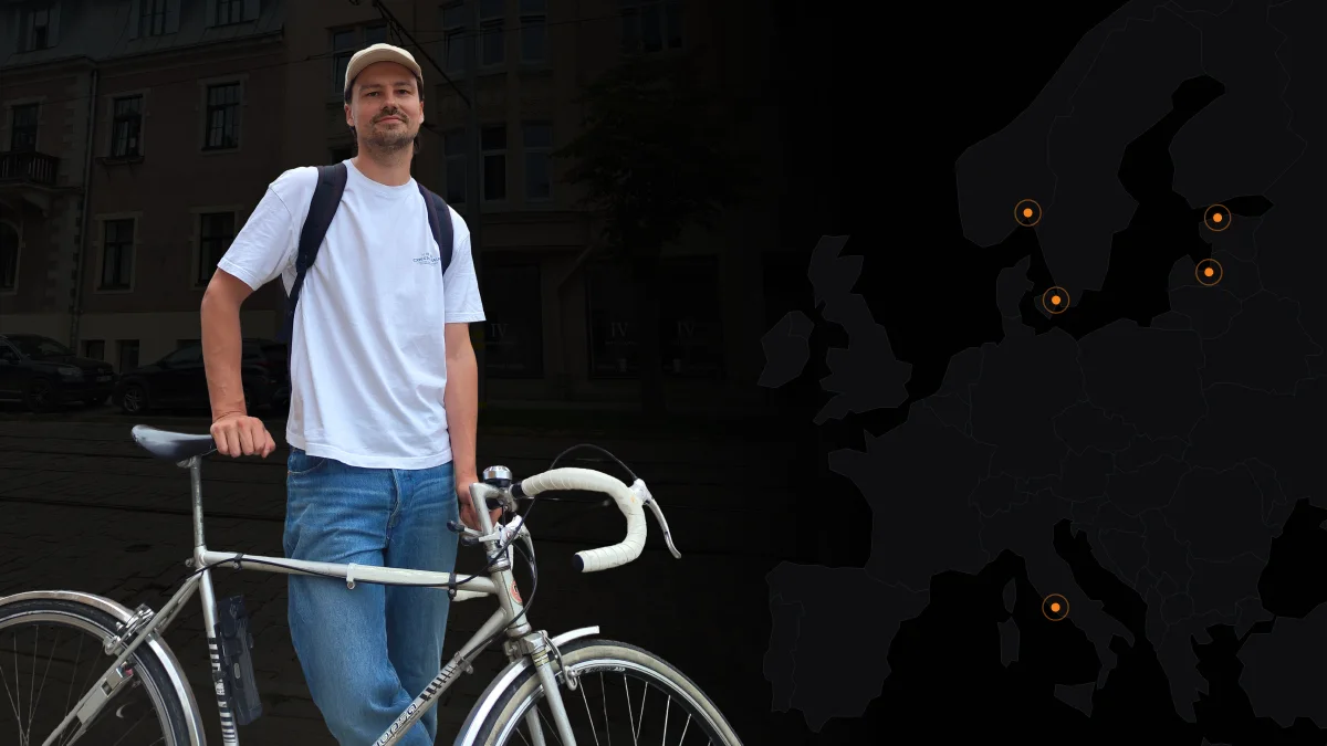 Ēriks with his bike, beside a map of Europe marking cities he's worked with startups in